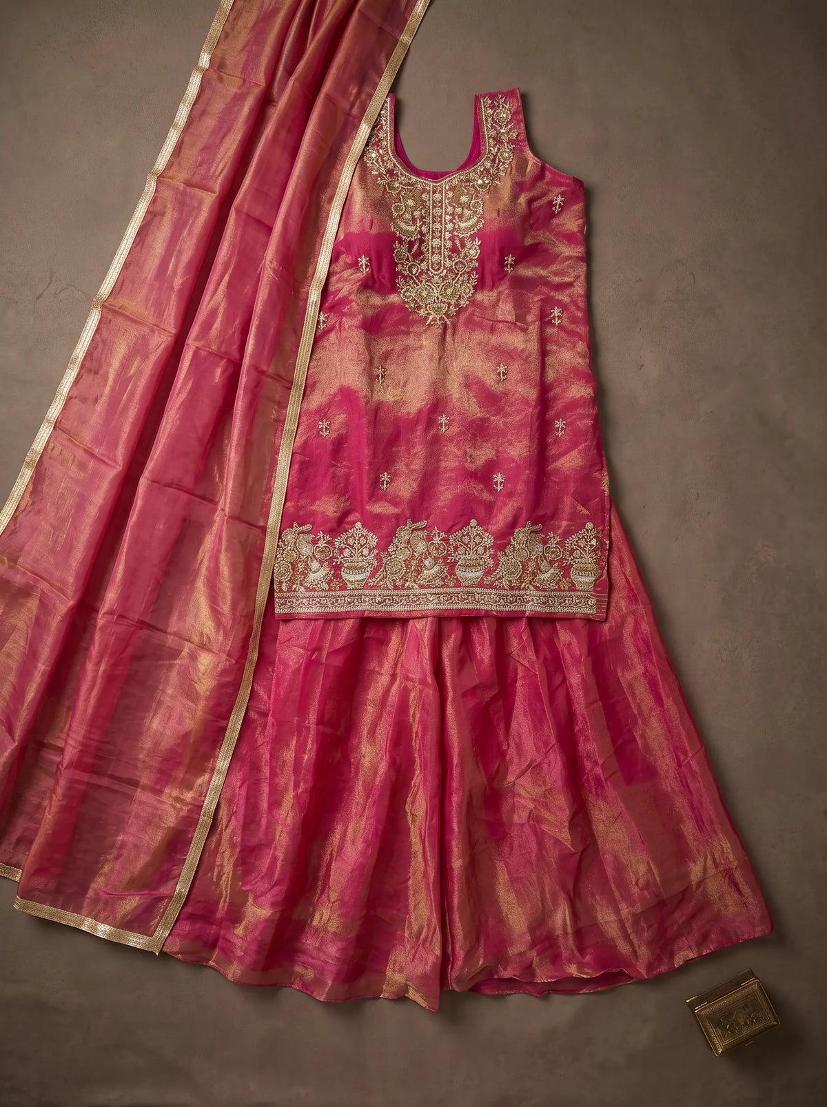 Fuchsia pink and metallic gold tissue silk sharara set with sequin and cut-bead embellished top, laid flat with matching dupatta
